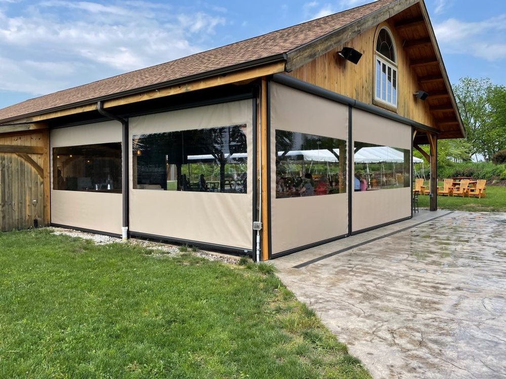Outdoor enclosed patio with wooden structure and clear vinyl windows
